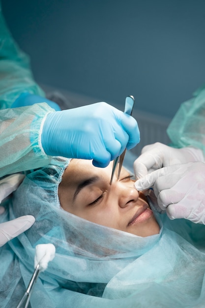 Doctors performing rhinoplasty high angle