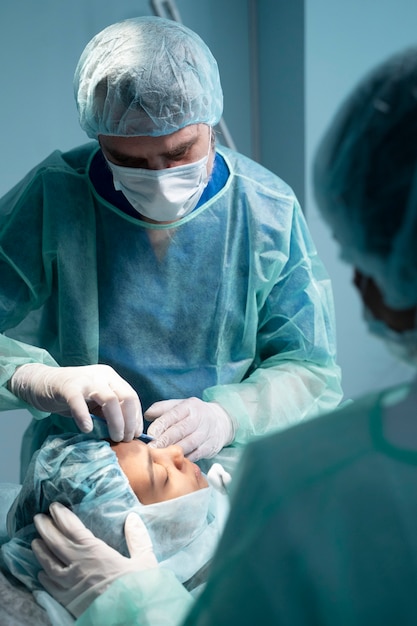Doctors performing rhinoplasty on young patient