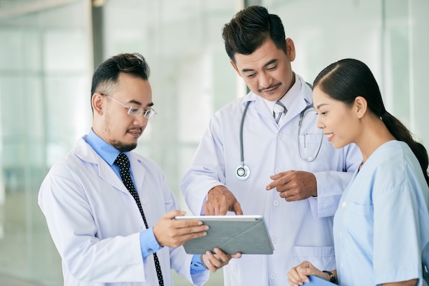 Doctors reading data on digital tablet