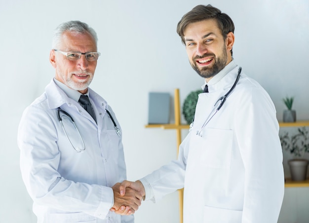 Doctors shaking hands and looking at camera