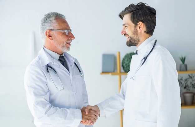 Free photo doctors shaking hands and looking at each other