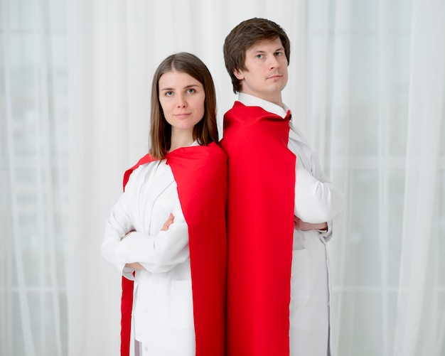 Free photo doctors with capes posing together