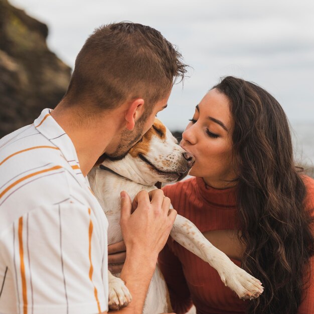 Dog kissed by couple