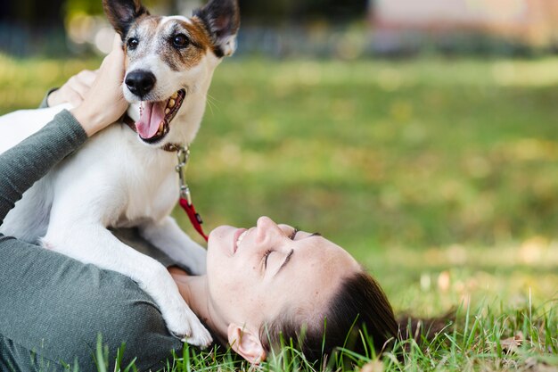 Dog playing with woman in grass