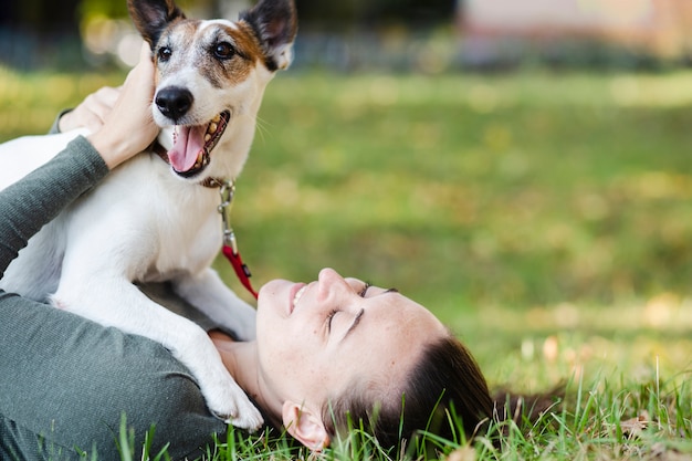 Собака играет с женщиной в траве