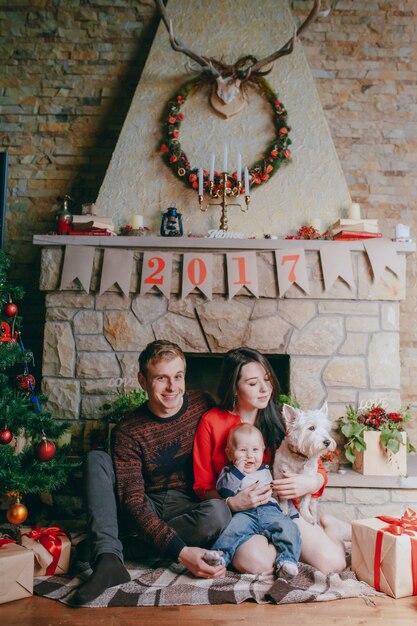 Dog sitting on the wooden floor with a family background