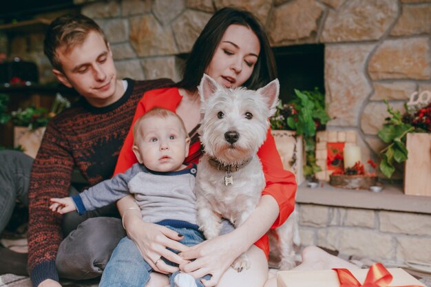 Dog sitting on the wooden floor with a family background