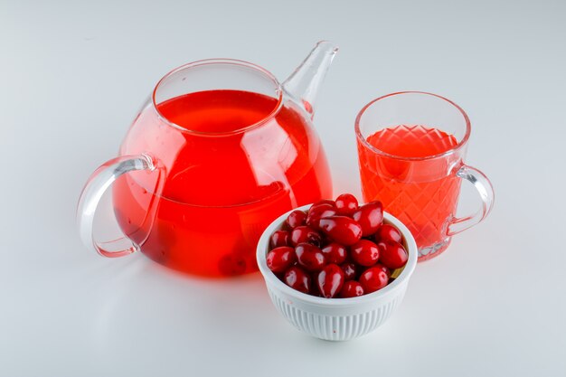 Dogwood berries in a bowl with drink high angle view on white