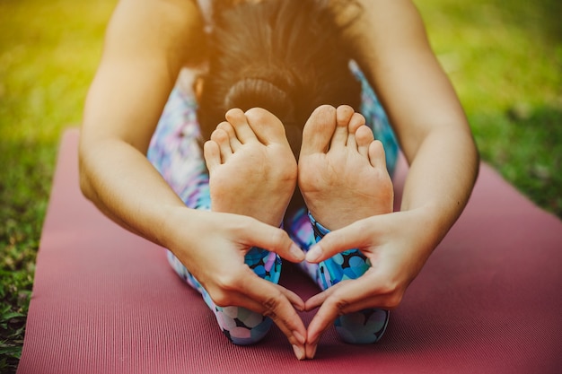 Free photo doing yoga and making a heart with hands