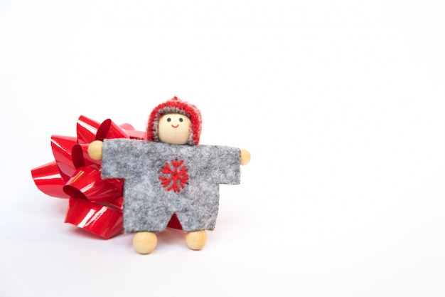 Doll in gray tunic giving a hug with a red bow