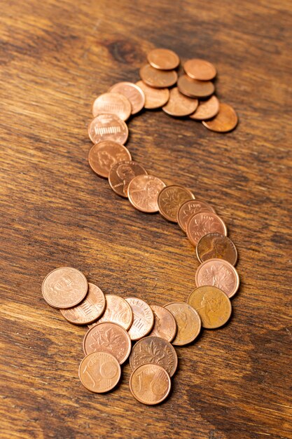 Dollar sign made out of coins on wooden background