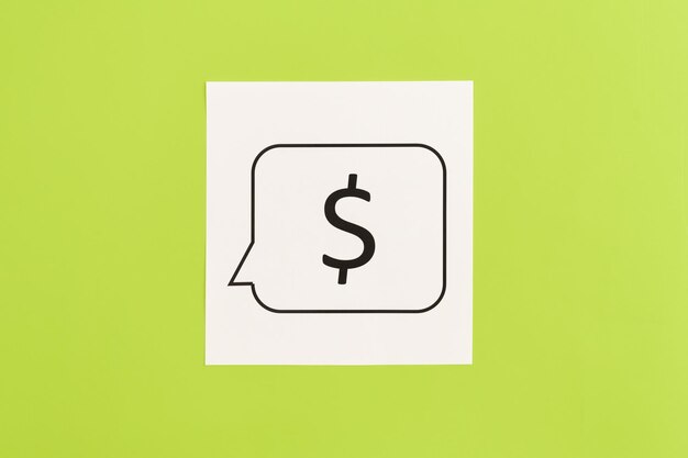 Бесплатное фото Знак доллара на белой бумаге на зеленом фоне плоской лежал