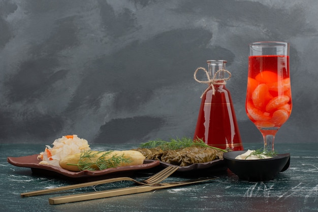 Dolma with glass and bottle of juice on marble background