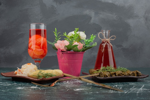 Dolma with glass and bottle of juice on marble wall