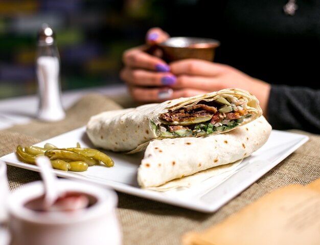 Doner in lavash meat lettuce cucumber tomato spicy pepper side view