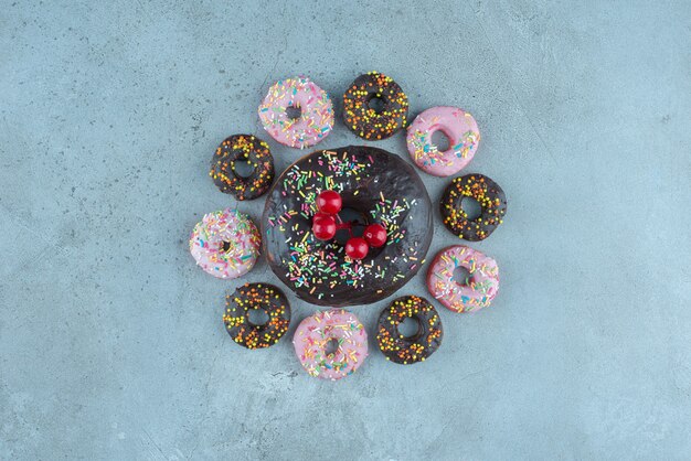 Donut arrangement decorated with a christmas berry ornament on marble.