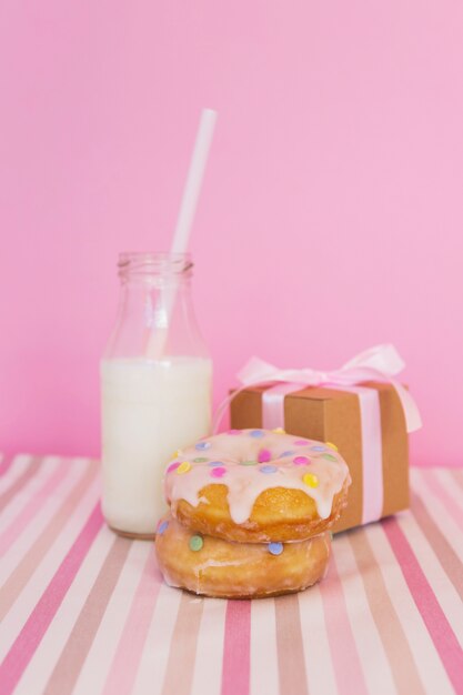 Donut with candle, present and milk