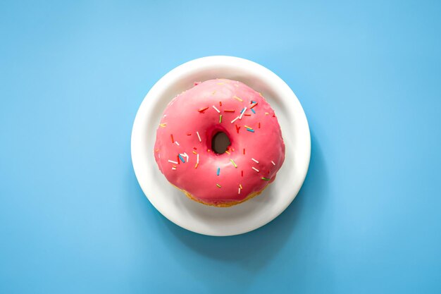 Donut with pink icing on a colored background isolated