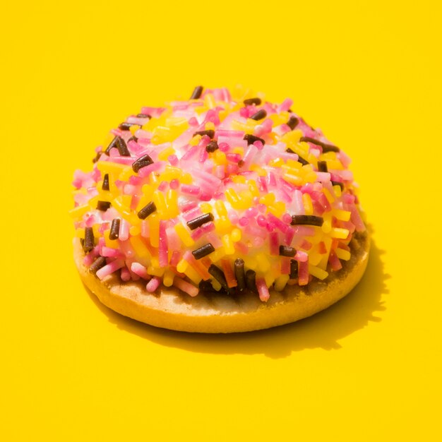 Пончик, завернутый с окропляет на желтом фоне