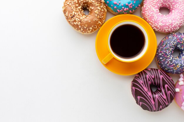 Donuts next to coffee copy space