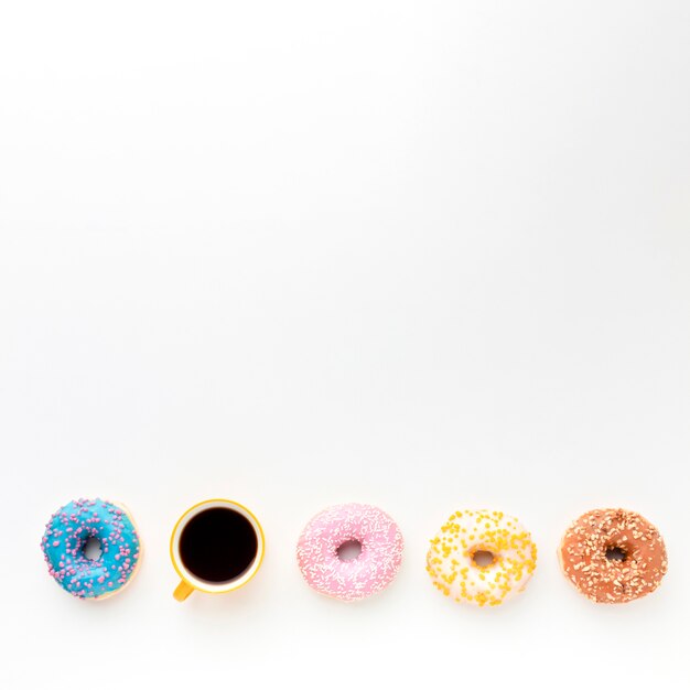 Donuts and coffee on plain background