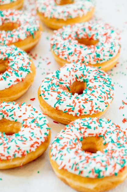 Free photo donuts with white chocolate cream and sprinkles sugar