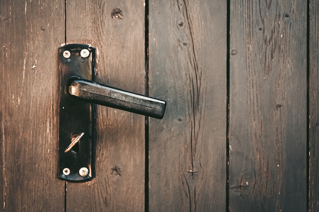 Door handle with a key on a wooden door