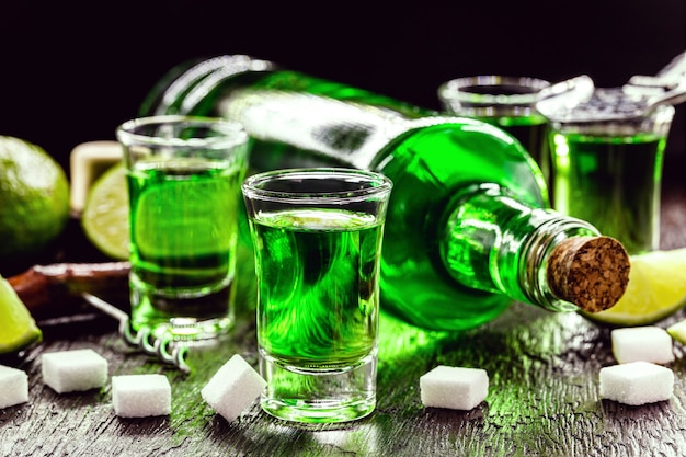 Doses of absinthe with sugar cubes. absinthe bottle, green distilled drink Premium Photo