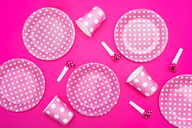 분홍색 배경에 점선 된 접시와 휘파람과 컵