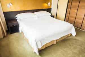 Free photo double bed with white sheets