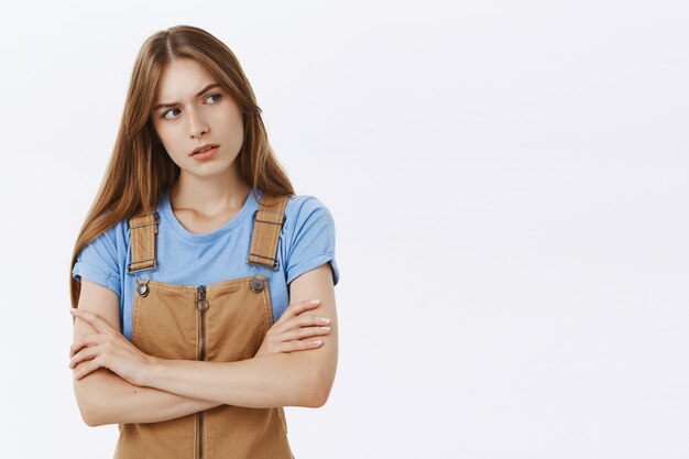 Doubtful and suspicious young woman looking right with uncertain face