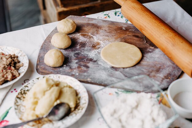 тесто мясной тесто в процессе приготовления теста на коричневом дереве деревенский стол