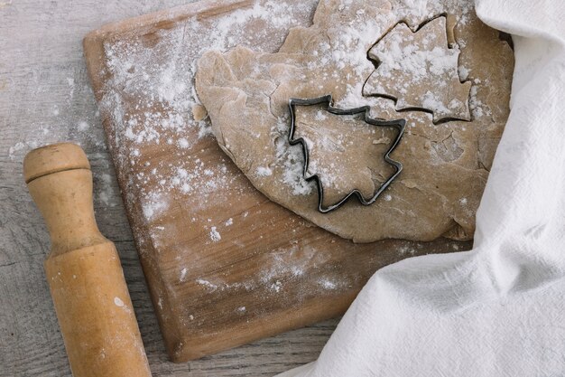 Dough near cookie cutter on cutting board 