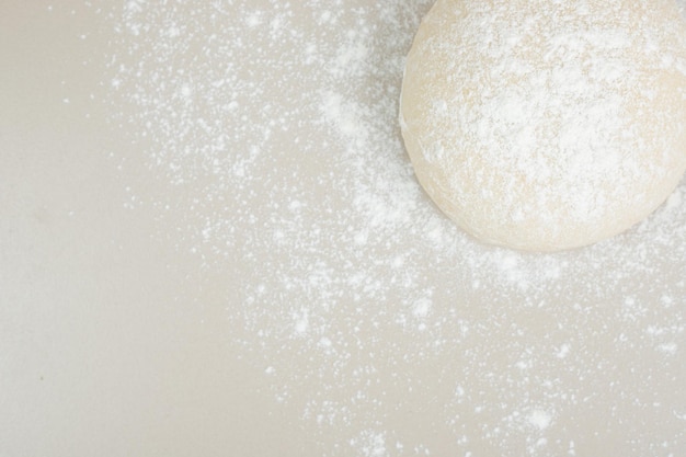 Free photo dough powdered with flour on white table.