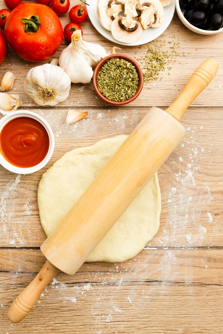 Free Photo dough with roller and garlic