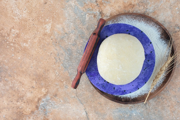 Free photo dough with rolling pin and flour on marble