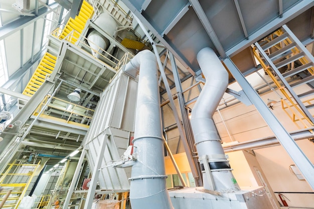 Down up view of modern operational plant with grey pipes and ladders heavy industry machinery metalworking workshop concept