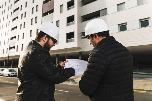 Free photo draftsmen discussing blueprints