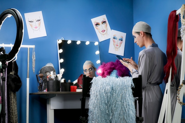 Free photo drag person putting on makeup