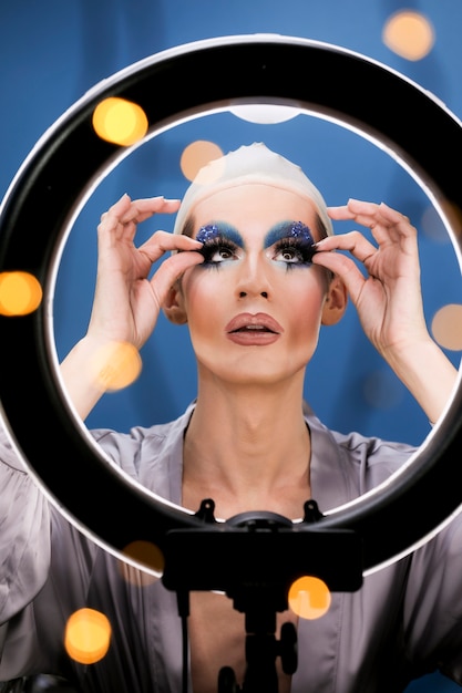 Free photo drag person putting on makeup