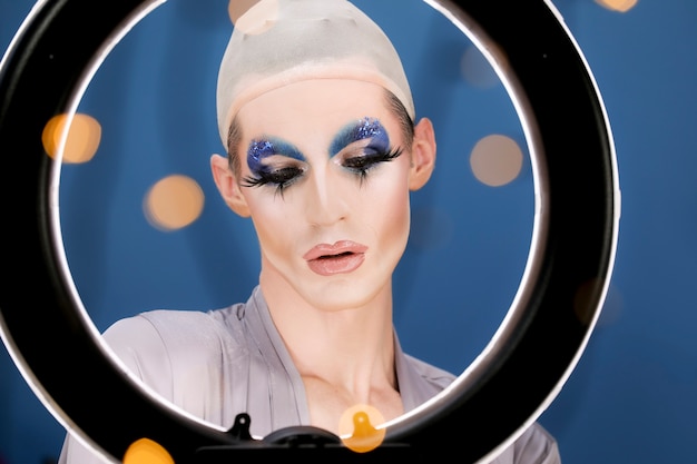 Free photo drag person putting on makeup