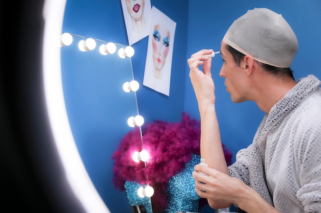 Free photo drag person putting on makeup