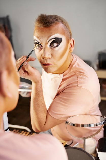 Drag queen putting makeup on high angle