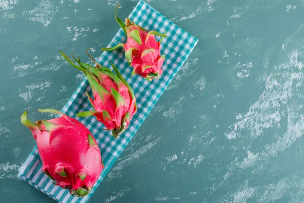 Dragon fruit on plaster and picnic cloth. top view.