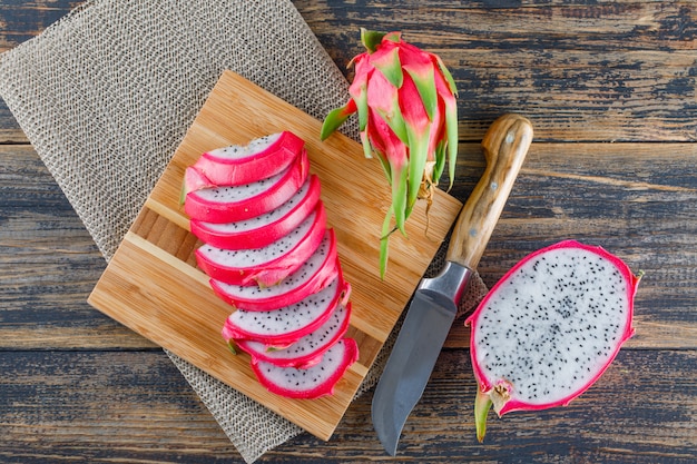 Dragon fruit with cutting board, knife flat lay on wooden table