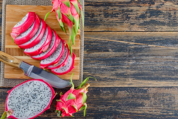 Dragon fruit with cutting board, knife flat lay on wooden table