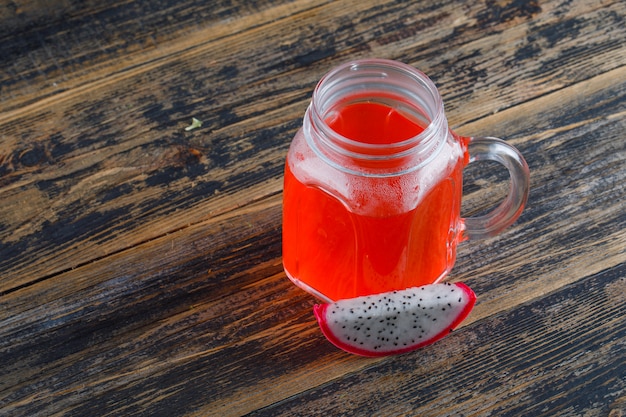 Free photo dragon fruit with juice high angle view on a wooden table