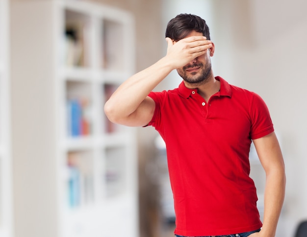 Free photo dramatic young man covering his eyes