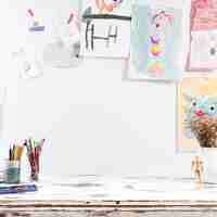 Free photo drawing table with children paintings