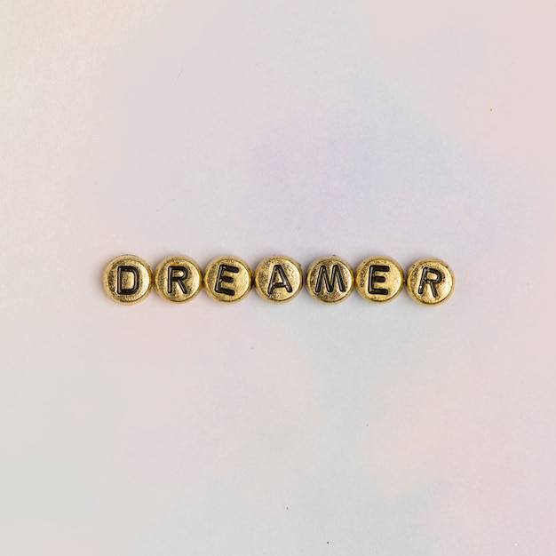 Free photo dreamer beads text typography on pastel